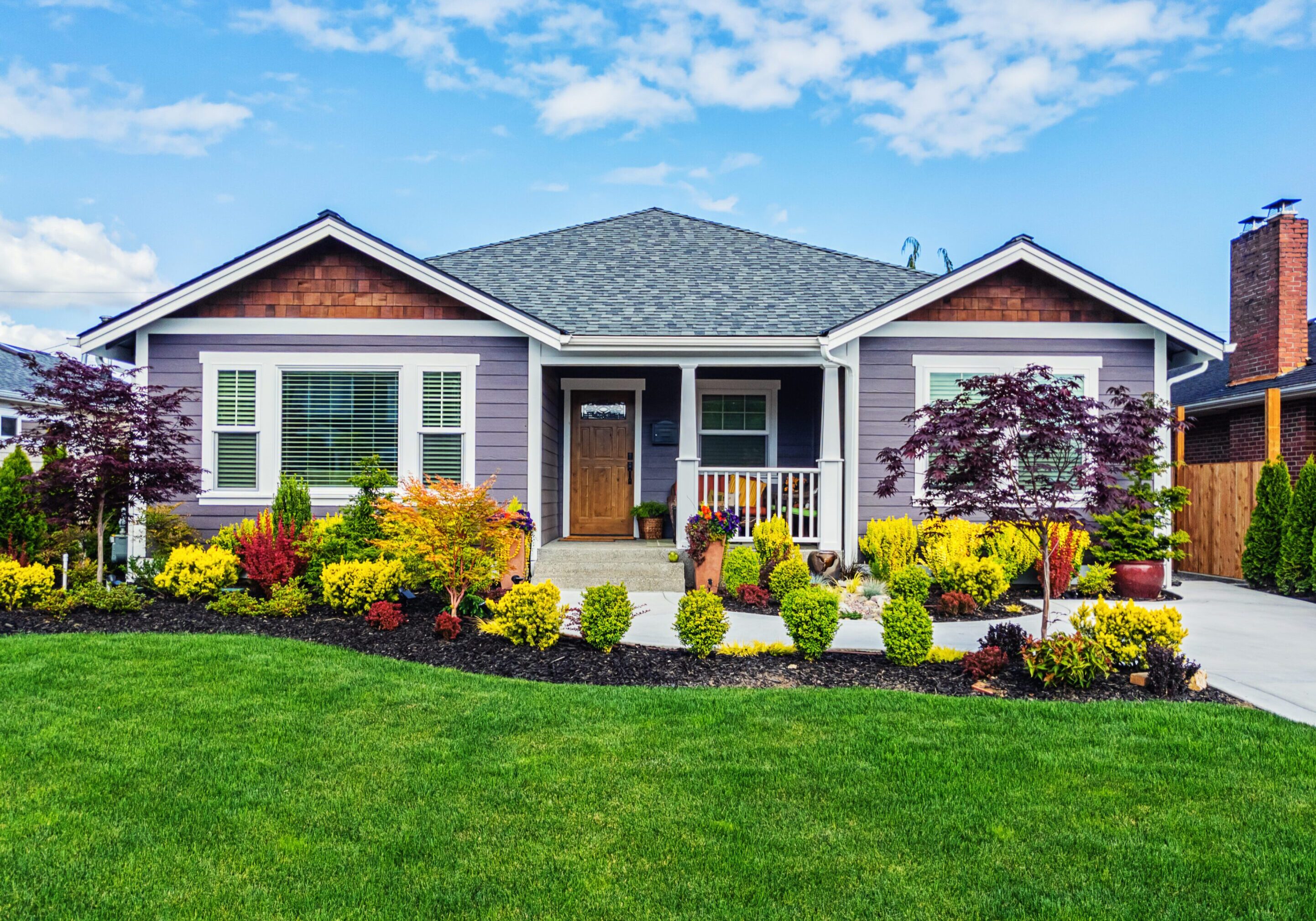 Photo of a modern custom single-level suburban home on a sunny summer day